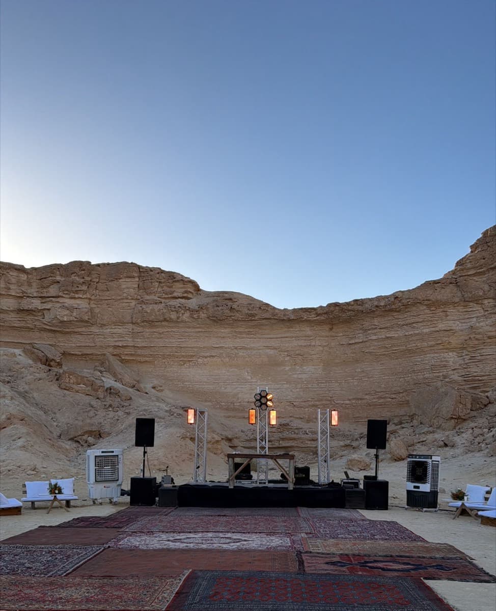במה במדבר מול צוק, עם רמקולים, תאורה ושטיחים